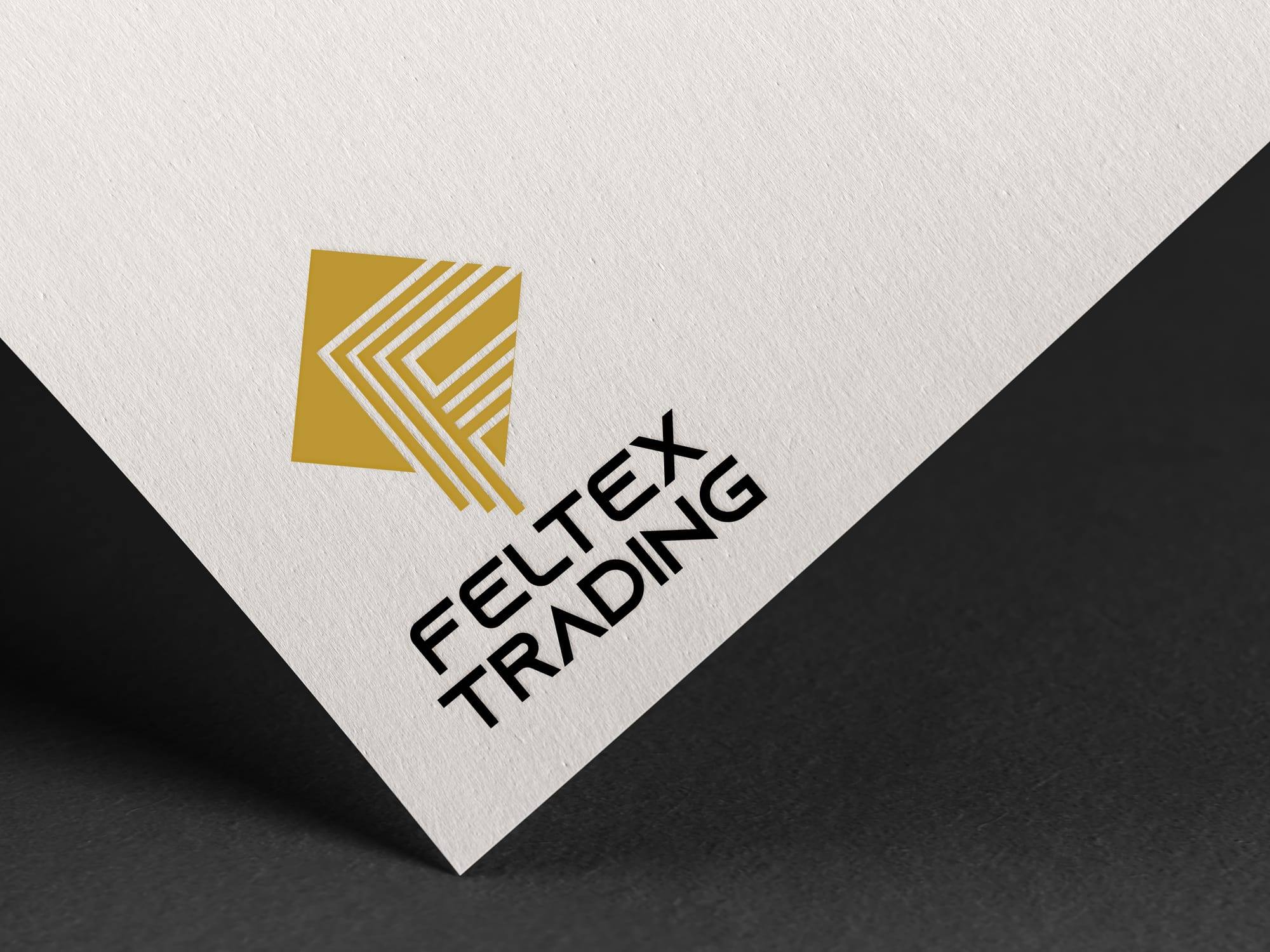 Feltex Trading logo, a gold folded mark above bold black lettering, on textured paper