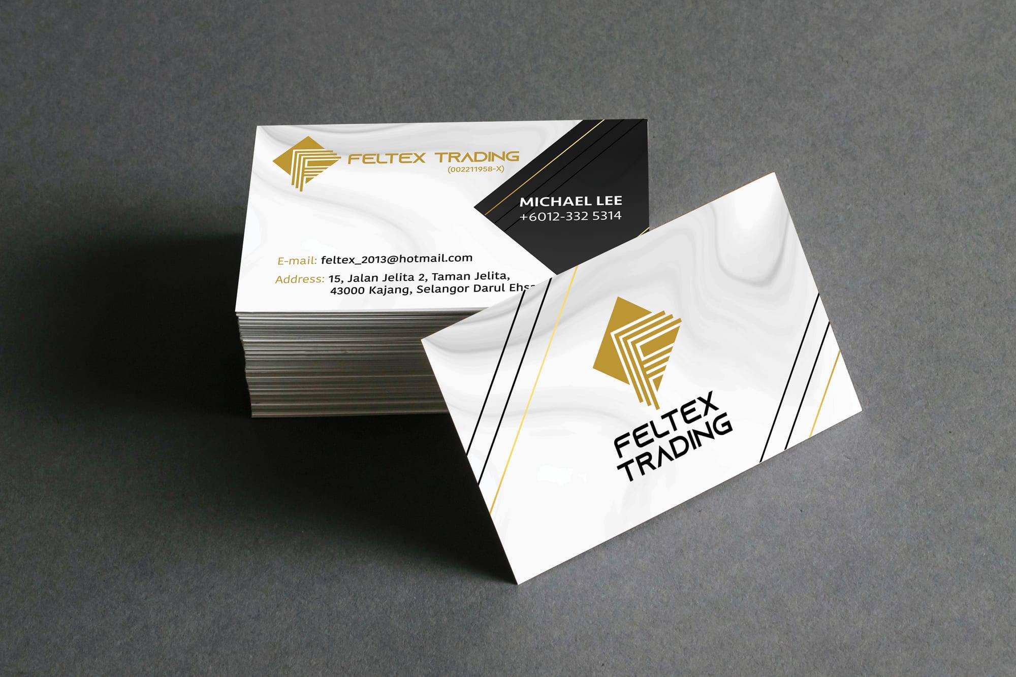 A stack of Feltex Trading name cards in white, black and gold