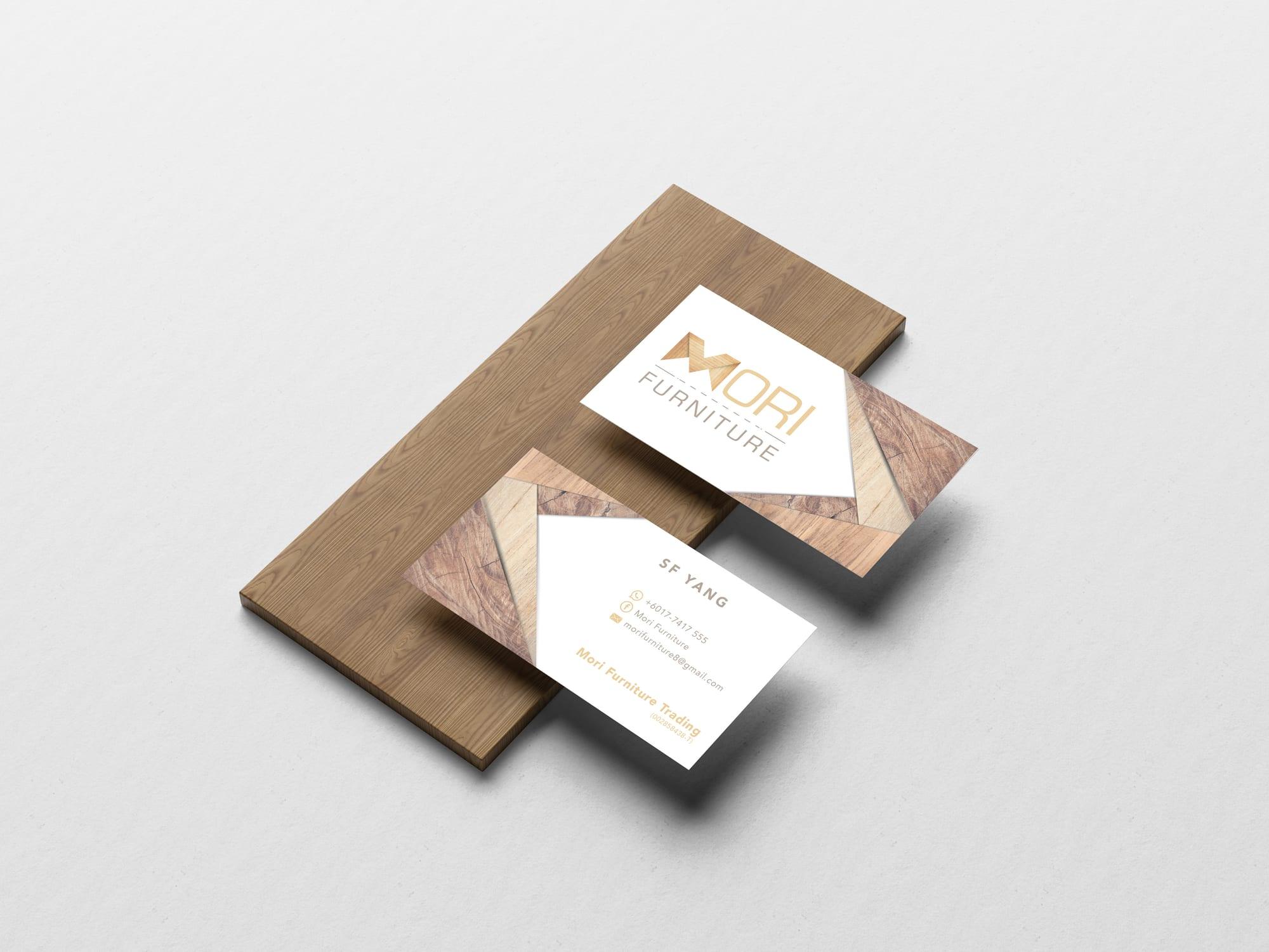 Front and back of Mori Furniture name cards on a wooden board
