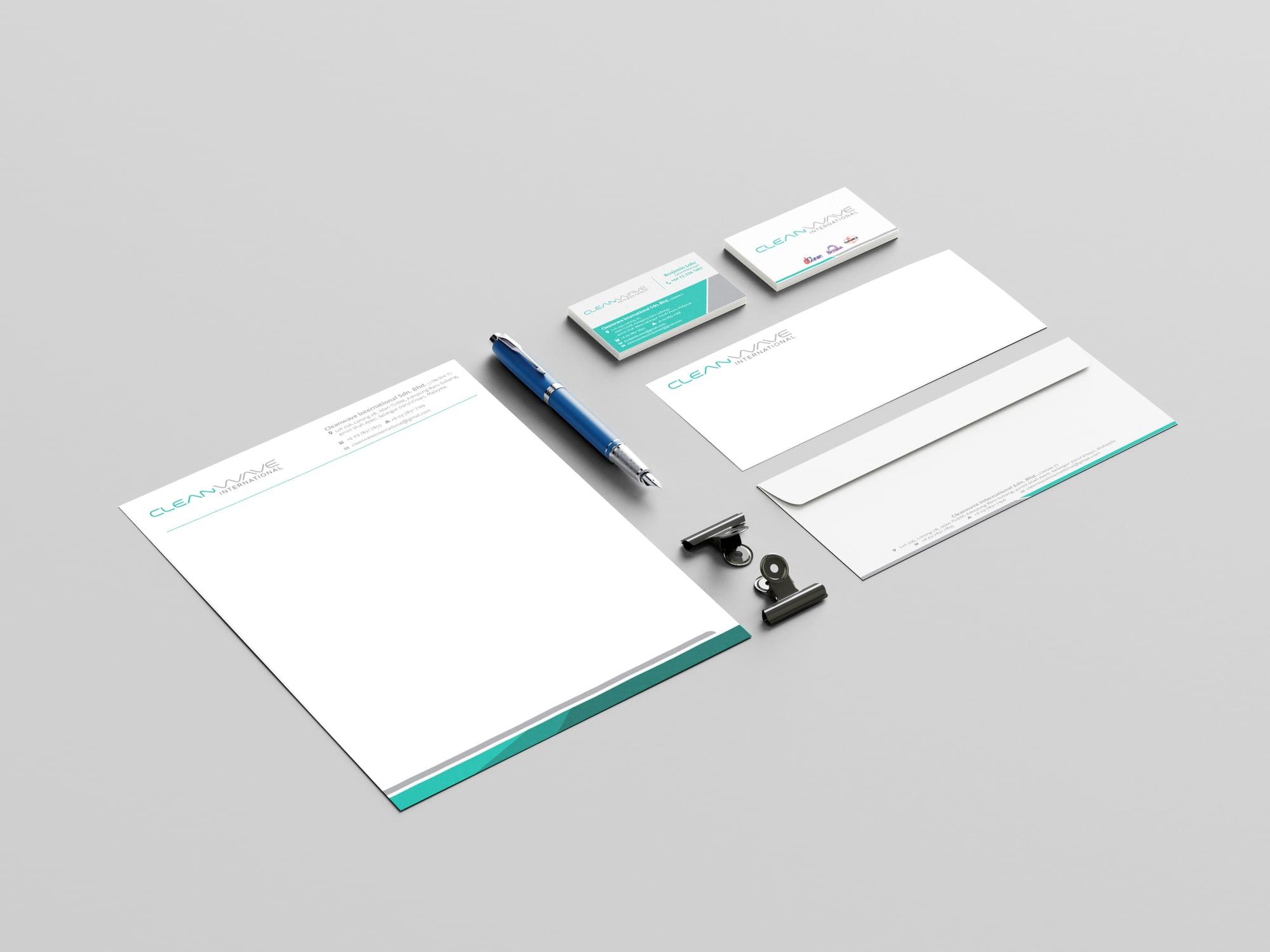 Cleanwave International letterhead, envelopes and name cards laid out with a pen and clips